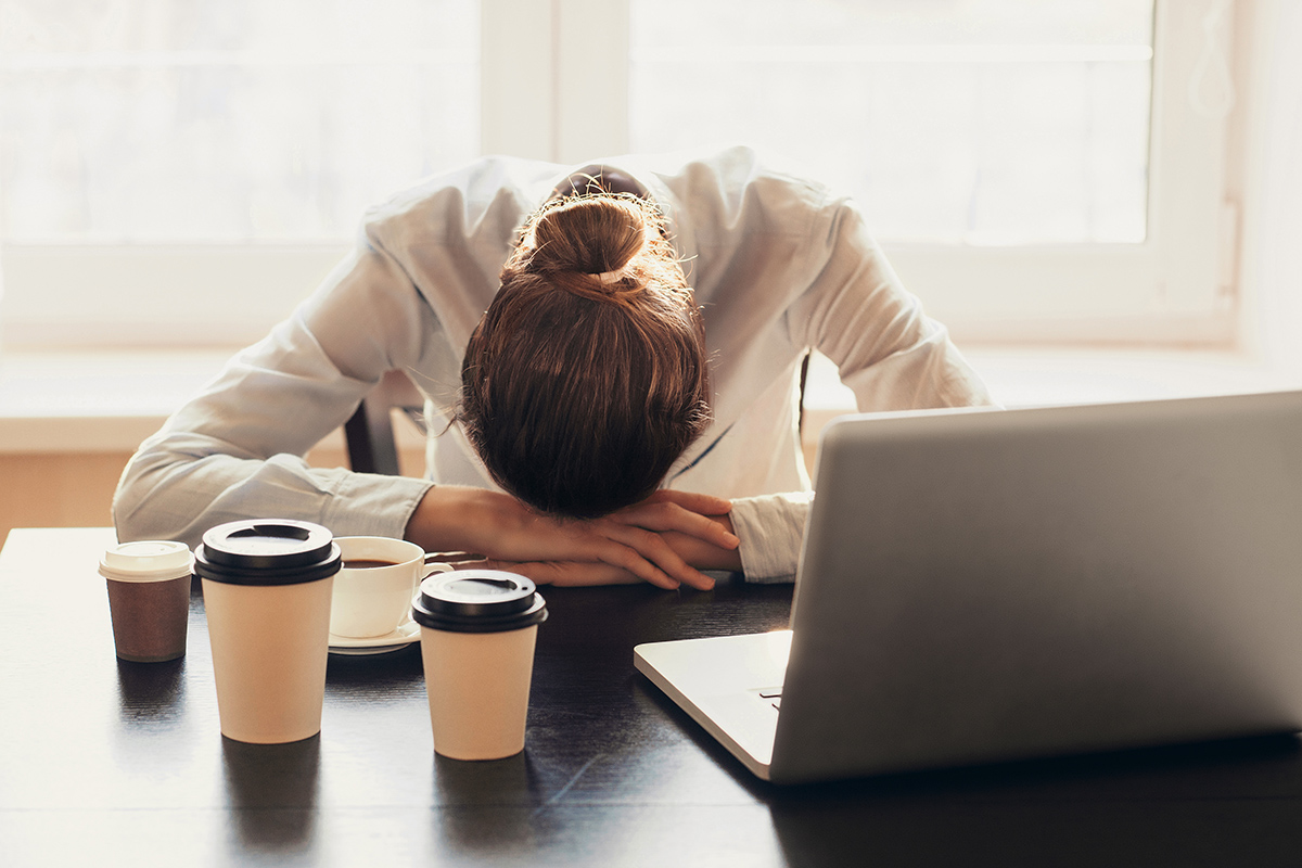 Exhausted female office worker face down on her desk